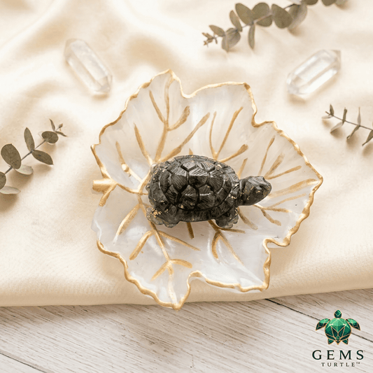 Crystal charging plate with turtle figurine and selenite leaf design, enhancing crystal energy and decor elegance.