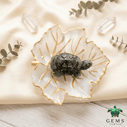Crystal charging plate with turtle figurine and selenite leaf design, enhancing crystal energy and decor elegance.