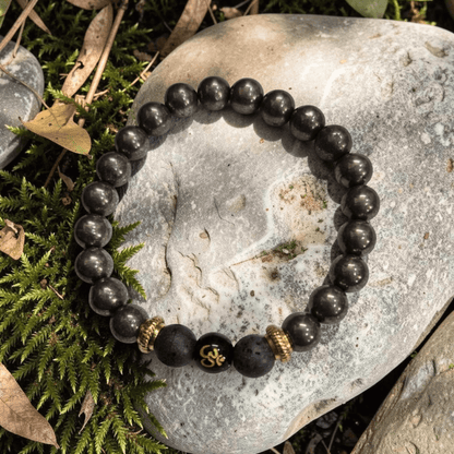 Om pyrite lava energy bracelet featuring Pyrite stones, Lava beads, and Om symbol on a natural stone background.