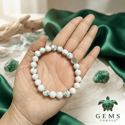 Howlite Natural Stone Bracelet For Calm and Stress Relief held in a hand, showcasing its elegant white beads with grey veining.